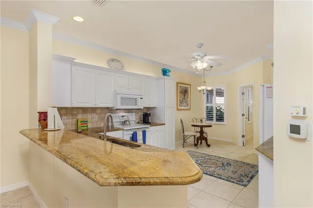 a kitchen with kitchen island granite countertop a sink a stove and cabinets