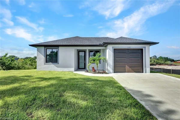 a front view of a house with a yard and garage