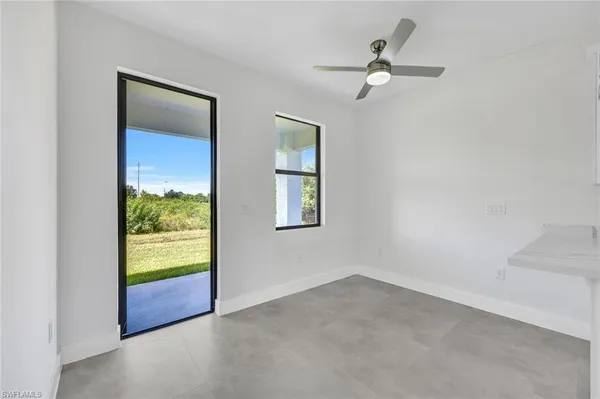 an empty room with window and ceiling fan