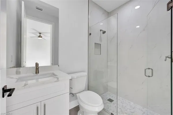 a bathroom with a sink toilet vanity and shower
