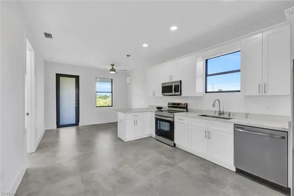 a kitchen with granite countertop a sink stainless steel appliances and cabinets