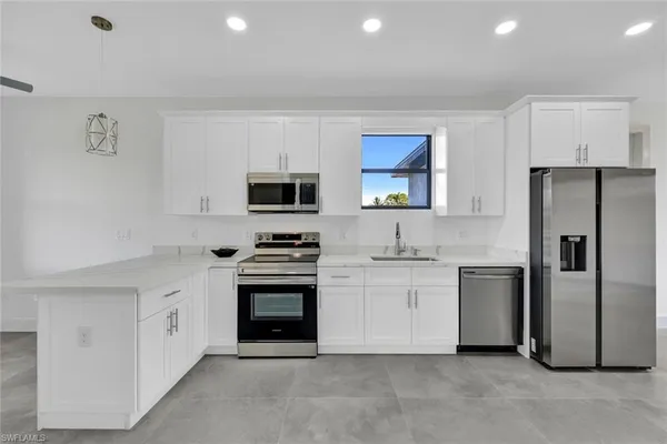 a kitchen with stainless steel appliances granite countertop a refrigerator stove and sink