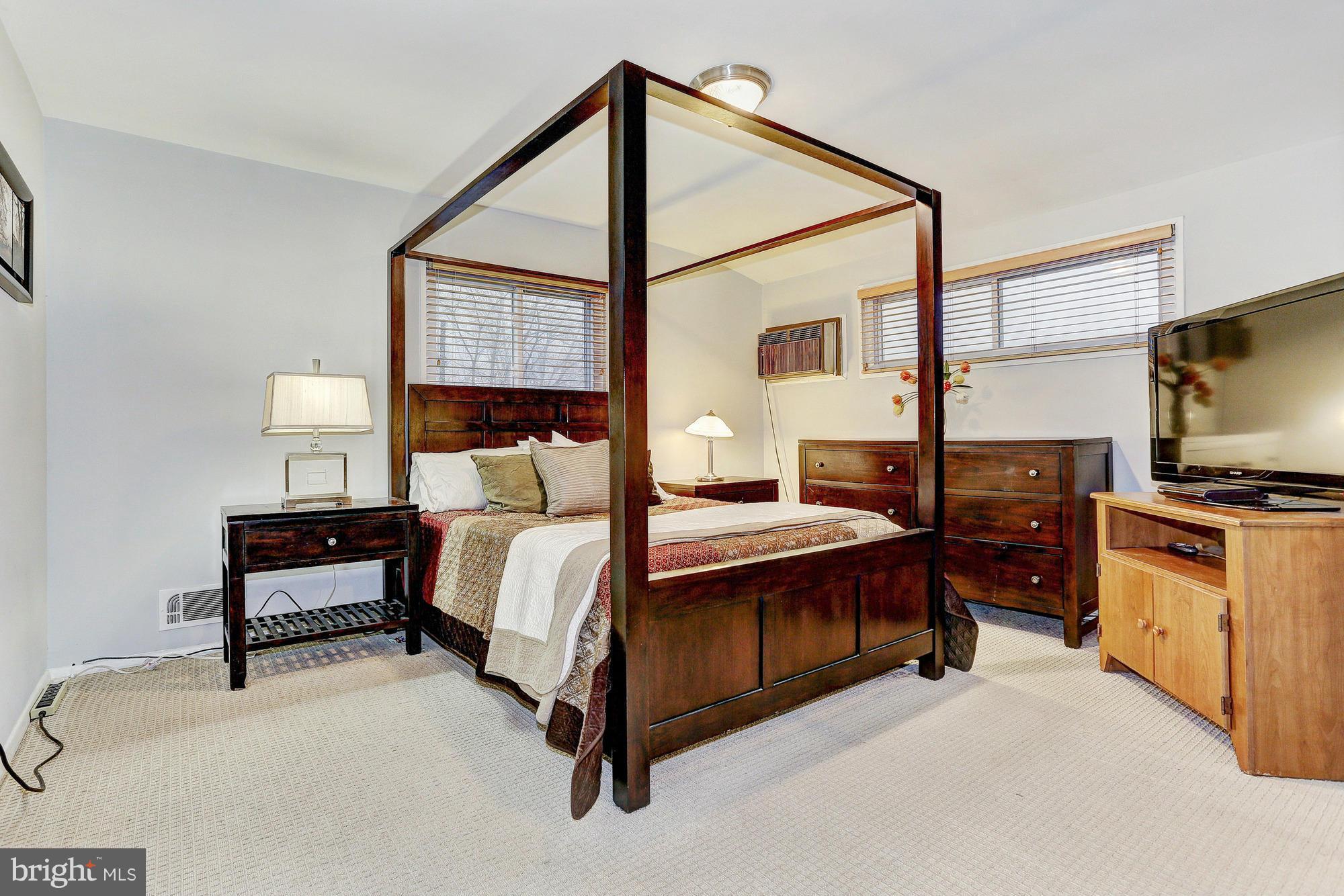 3303 Greenmead Road Windsor Mill, MD 21244 - Photo 14 of 20 a spacious bedroom with a bed and a flat screen tv