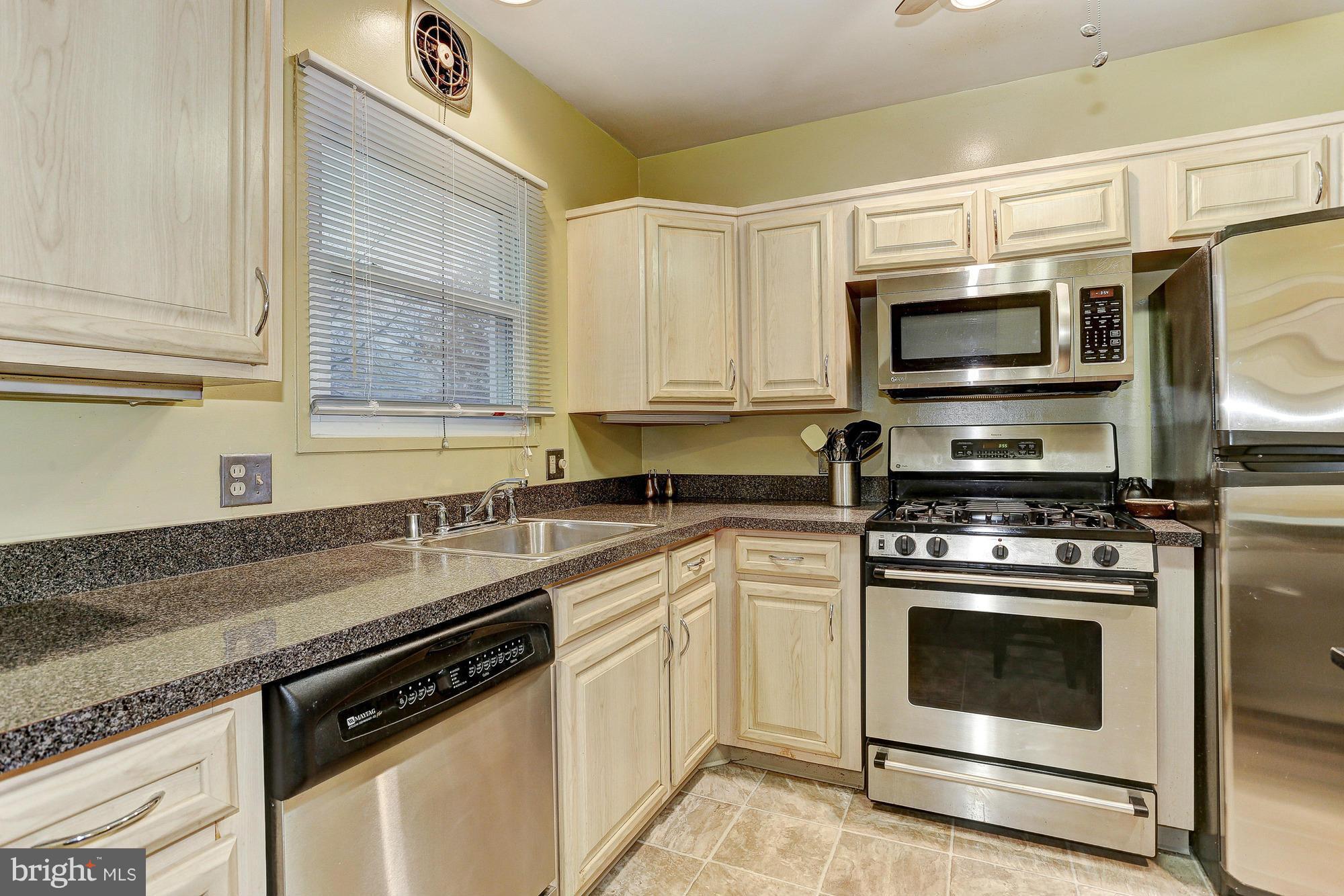 3303 Greenmead Road Windsor Mill, MD 21244 - Photo 8 of 20 a kitchen with stainless steel appliances granite countertop a sink a stove top oven and cabinetry