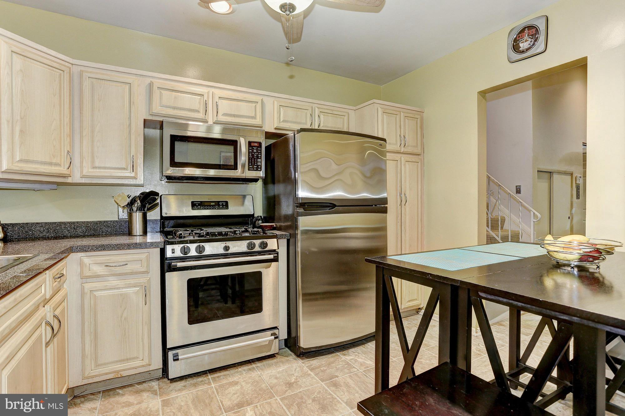 3303 Greenmead Road Windsor Mill, MD 21244 - Photo 9 of 20 a kitchen with stainless steel appliances granite countertop a stove microwave and refrigerator