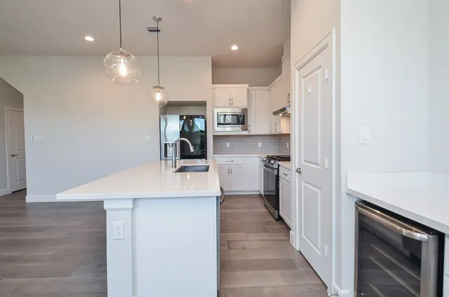 a kitchen with kitchen island a sink stainless steel appliances and cabinets