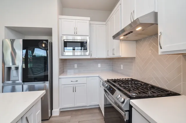 a kitchen with stainless steel appliances a sink stove and cabinets