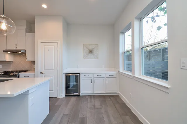 a kitchen with granite countertop a stove a sink and a refrigerator
