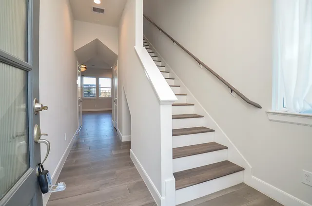 a view of a hallway with wooden floor and staircase
