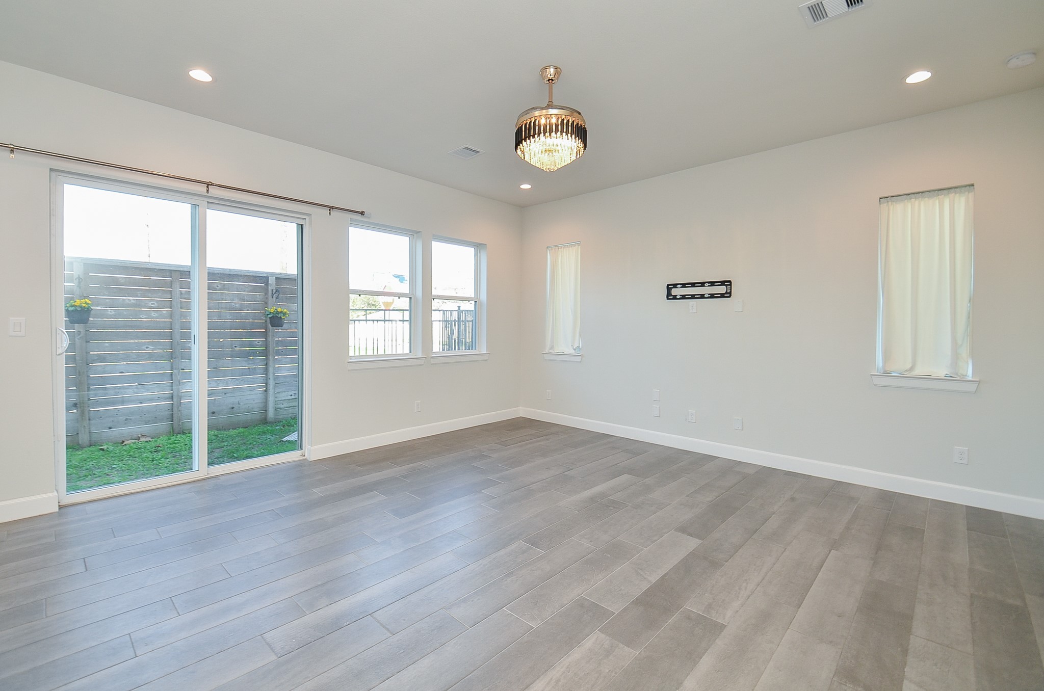 9577 Neuens Road, Unit F Houston, TX 77080 - Photo 7 of 26 an empty room with wooden floor and windows
