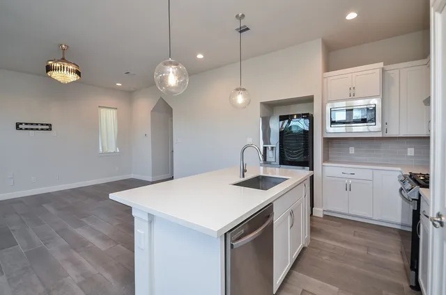 a kitchen with a sink chandelier and stove