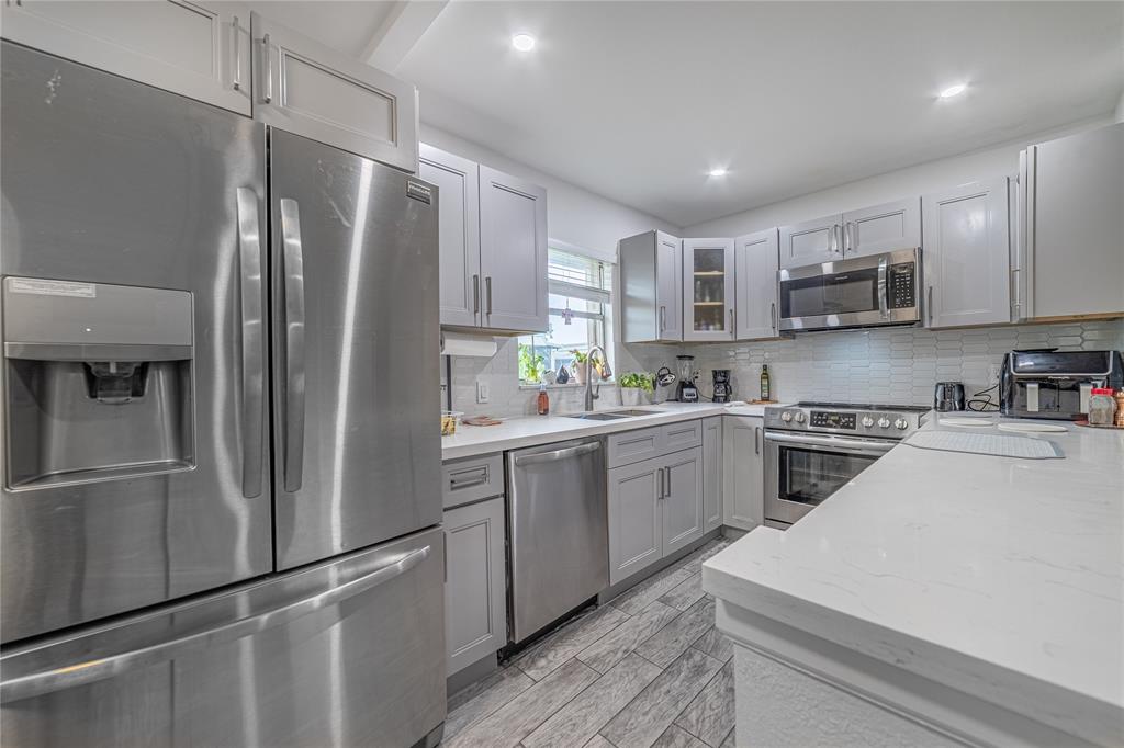 a kitchen with stainless steel appliances refrigerator and microwave
