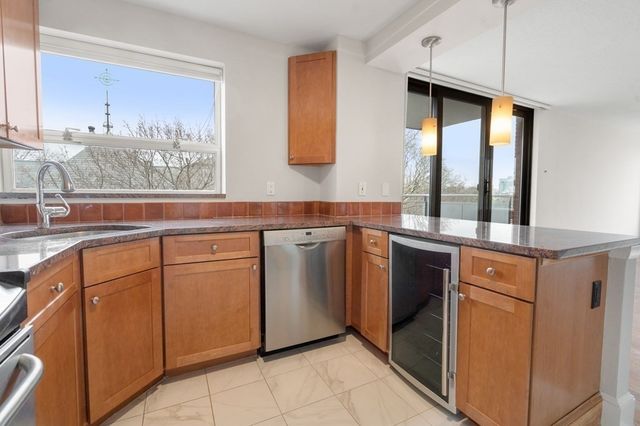 a kitchen with stainless steel appliances granite countertop a sink and a stove