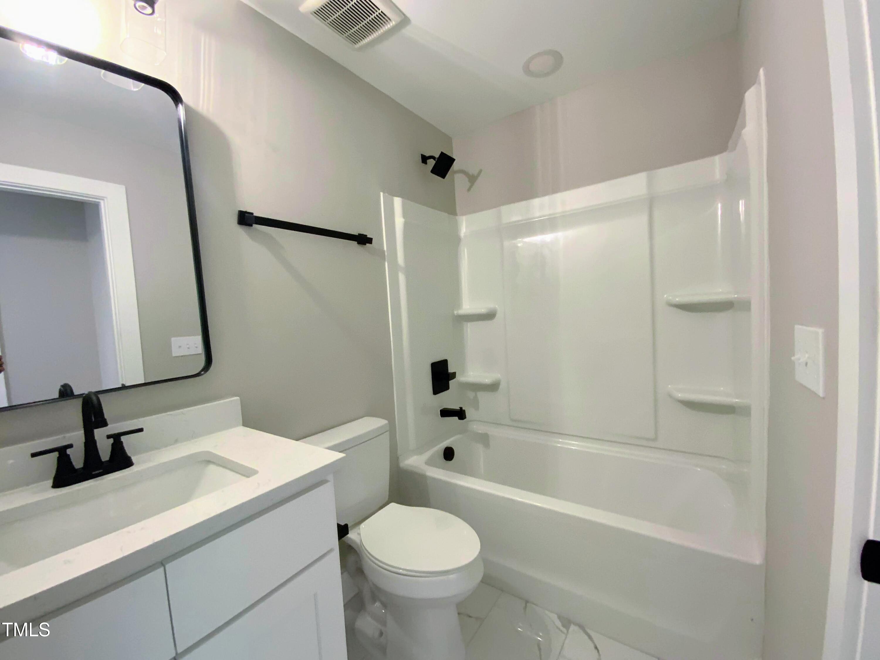 608 East Umstead Street Durham, NC 27701 - Photo 18 of 20 a bathroom with a sink a toilet and a mirror