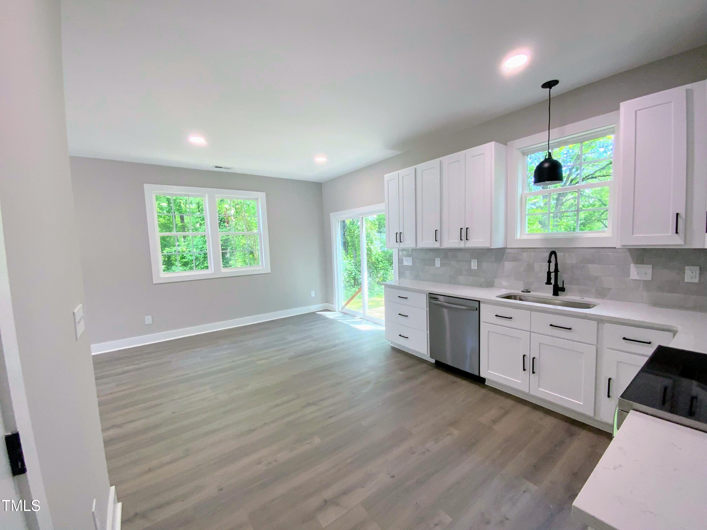 608 East Umstead Street Durham, NC 27701 - Photo 8 of 20 a kitchen with a sink wooden floor cabinets and a window