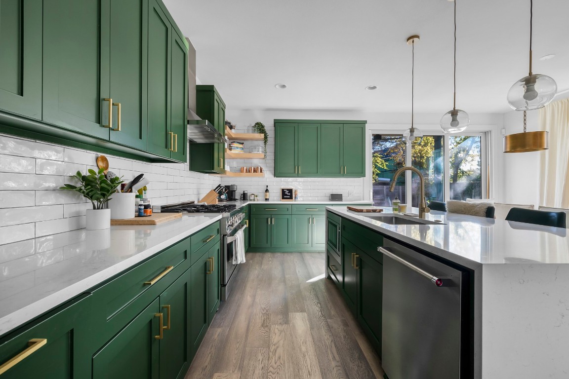 a kitchen with kitchen island granite countertop a sink a counter top space stainless steel appliances and cabinets