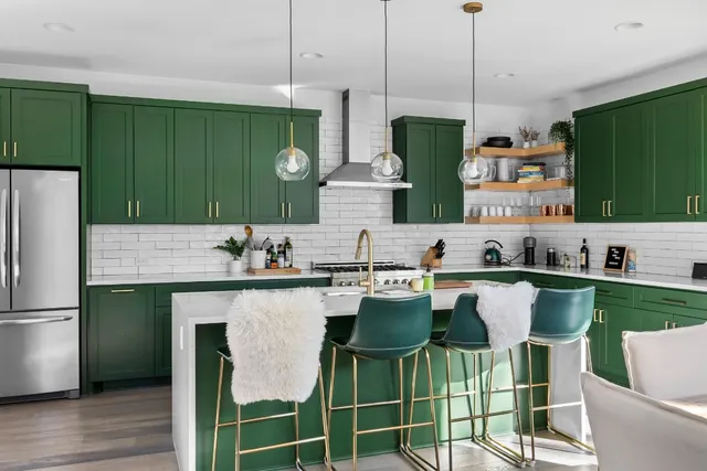 a kitchen with stainless steel appliances kitchen island a table and chairs in it