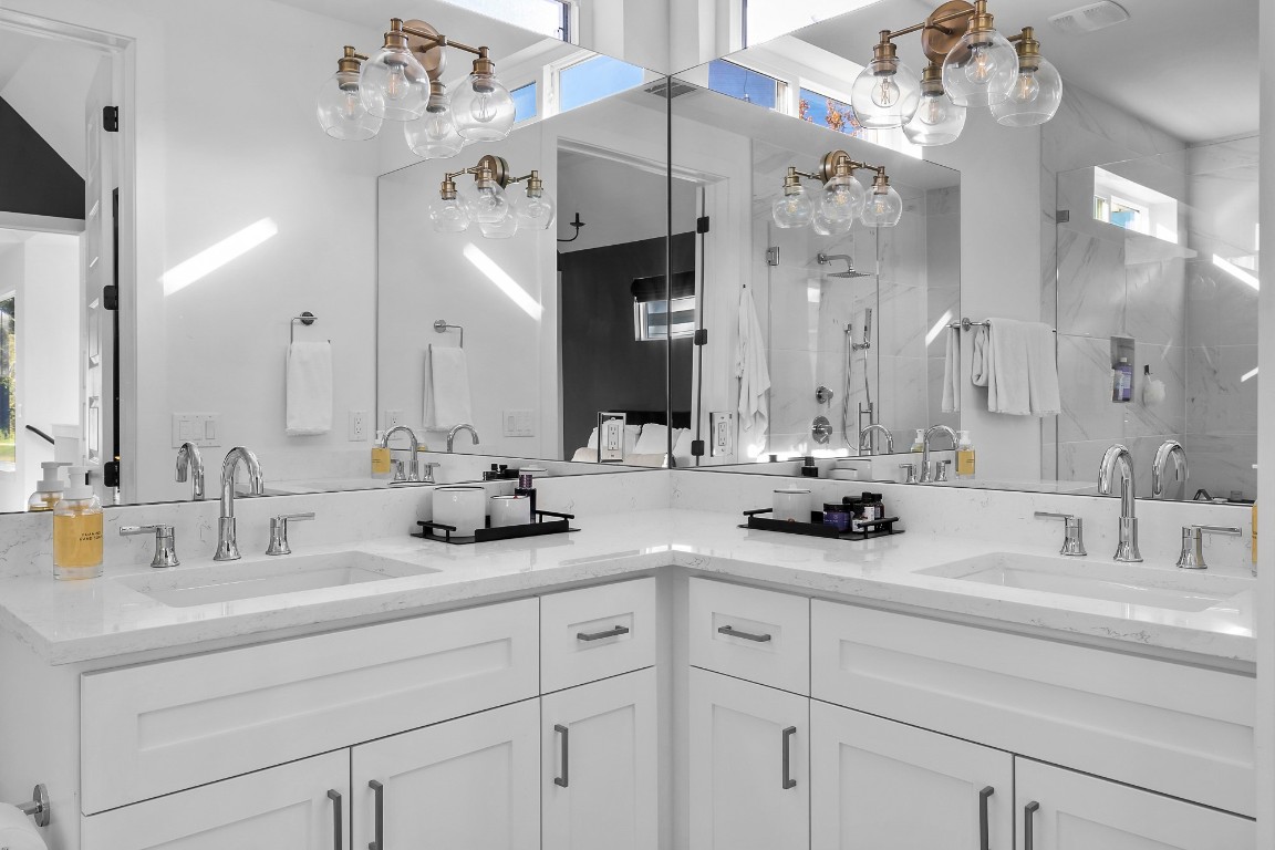 404 Powell Circle, Unit B Austin, TX 78704 - Photo 20 of 33 a bathroom with double vanity sinks a vanity a lamp and a mirror