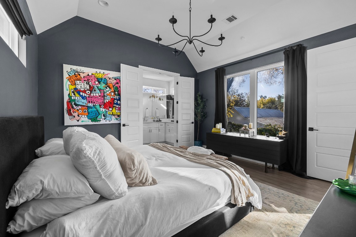 404 Powell Circle, Unit B Austin, TX 78704 - Photo 23 of 33 a bedroom with a bed chandelier and a window