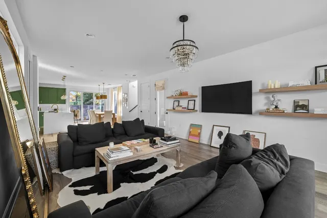 a living room with furniture a flat screen tv and kitchen view
