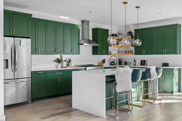 a kitchen with stainless steel appliances granite countertop a refrigerator a sink and a wooden floors