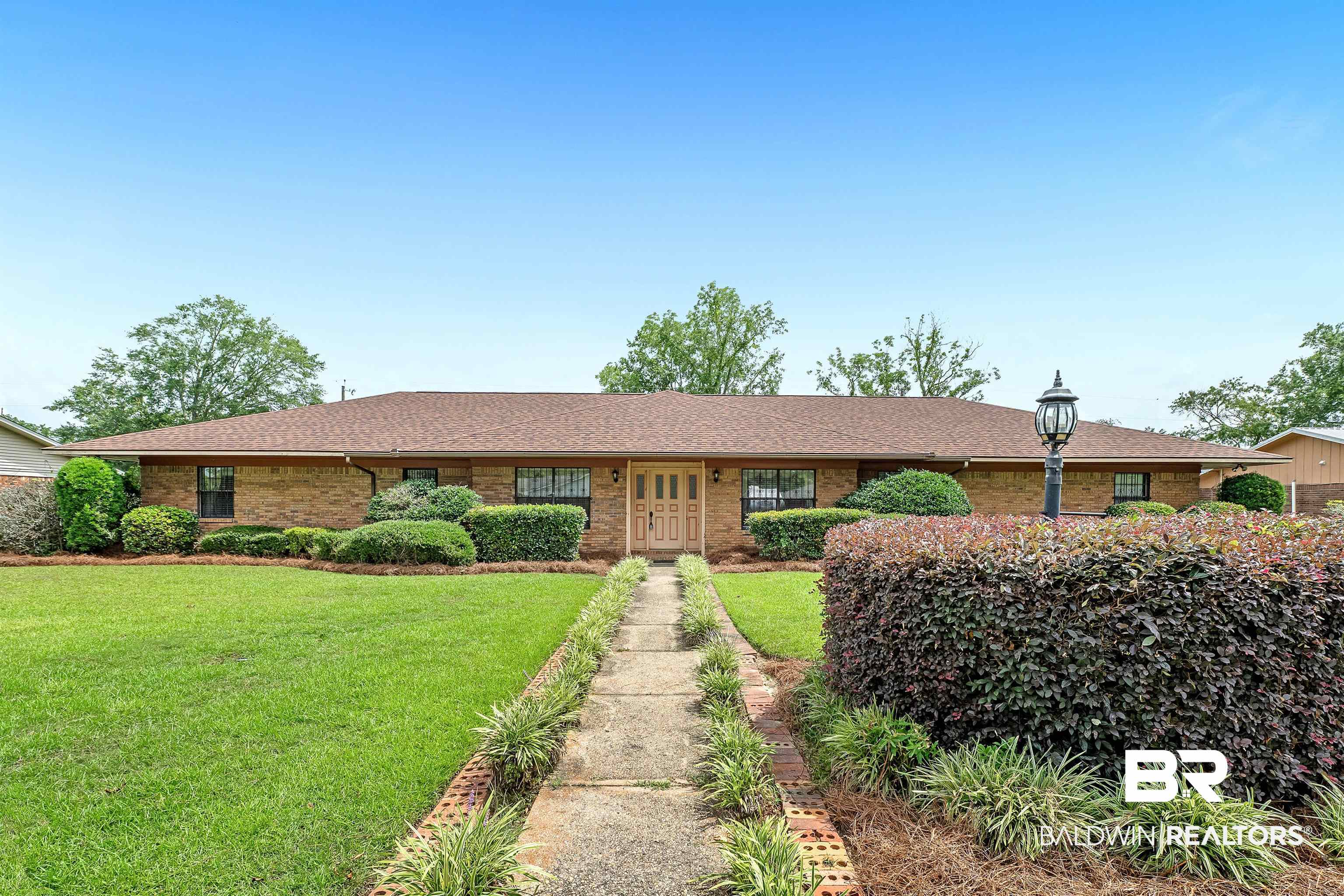 610 East Walker Avenue Foley, AL 36535 - Photo 2 of 38 Single story home featuring brick siding, a front yard, and a shingled roof