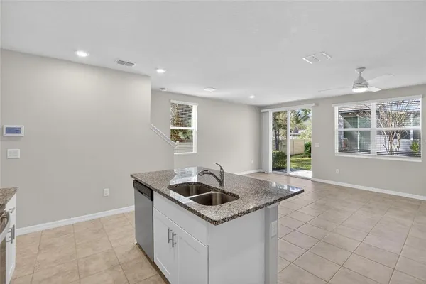 a view of a kitchen with refrigerator and white cabinets