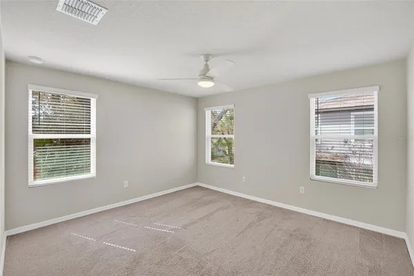 an empty room with a chandelier fan