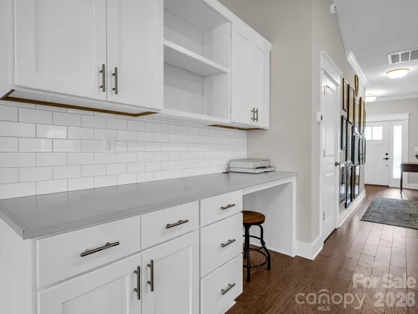 a kitchen with white cabinets and sink