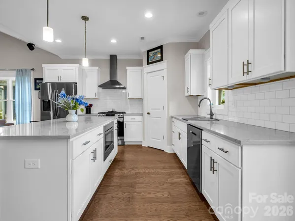 a large kitchen with stainless steel appliances granite countertop a stove a sink and a refrigerator