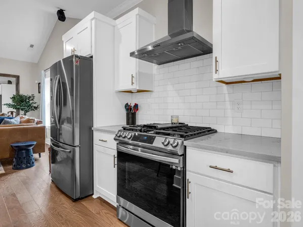 a kitchen with stainless steel appliances wooden floor sink and wooden cabinets