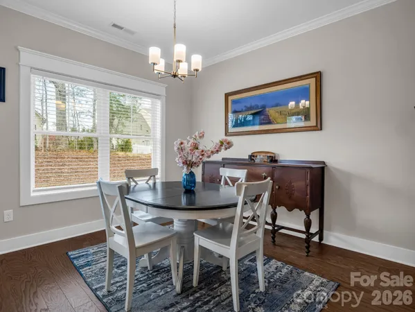 a view of a dining room with furniture a chandelier and wooden floor