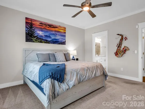 a bedroom with a bed and painting on the wall