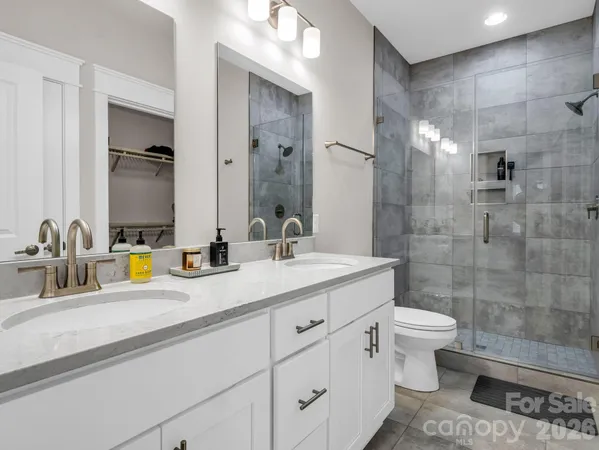 a bathroom with a double vanity sink a toilet and a mirror