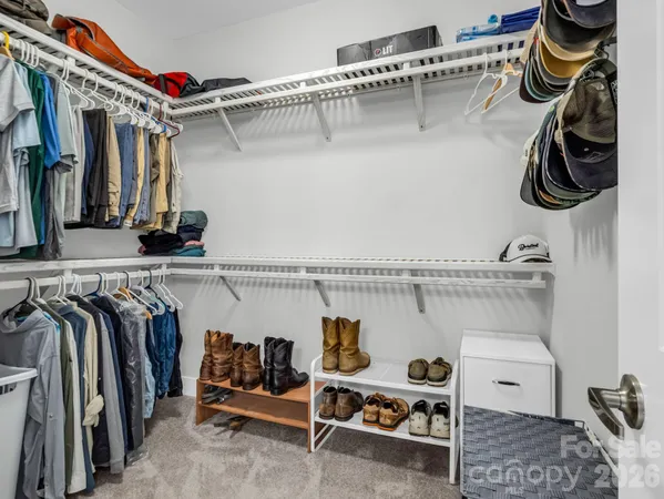 a view of walk in closet with clothes and shoes