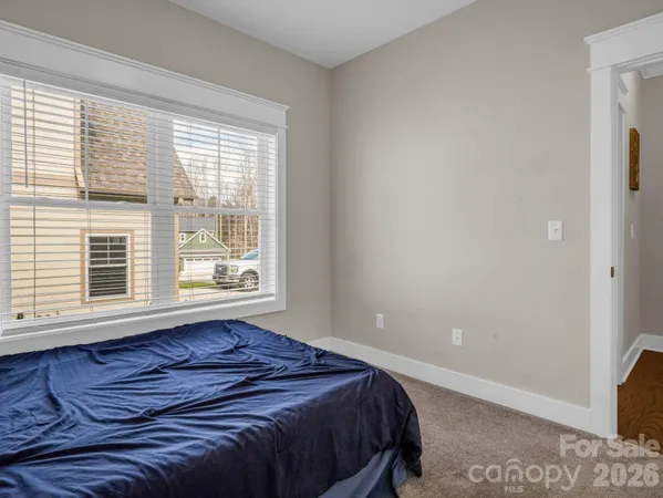 a bed sitting in a bedroom next to a window