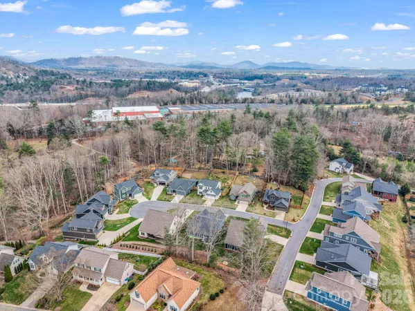 an aerial view of a house with a garden and lake view