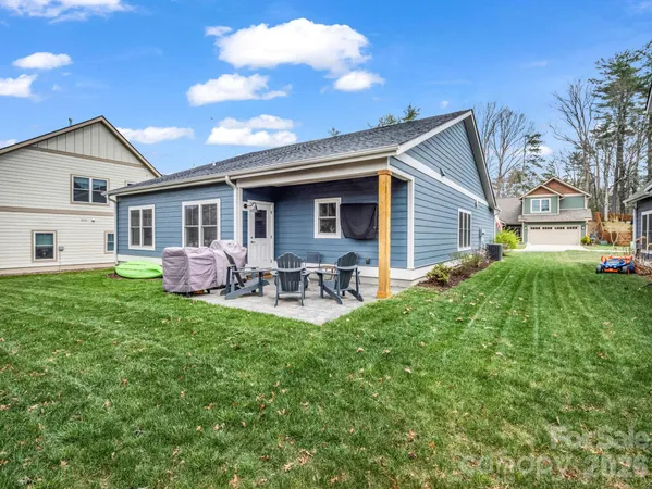 a view of a house with backyard and sitting area