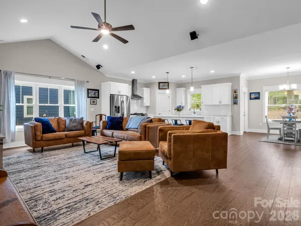a living room with furniture kitchen view and a dining table