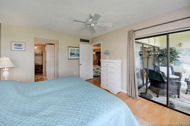 1950 Southwest Palm City Road, Unit 3209 Stuart, FL 34994 - Photo 23 of 64 Primary bedroom opens to the screened and enclosed patio.