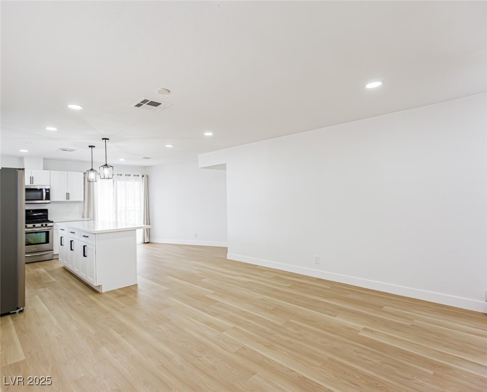 661 Riata Way Las Vegas, NV 89110 - Photo 8 of 30 Kitchen featuring a kitchen island, white cabinets, appliances with stainless steel finishes, pendant lighting, and recessed lighting