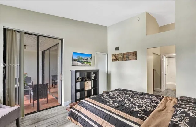 a bedroom with a bed and a dresser with wooden floor