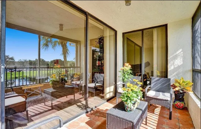 a balcony with furniture and a floor to ceiling window