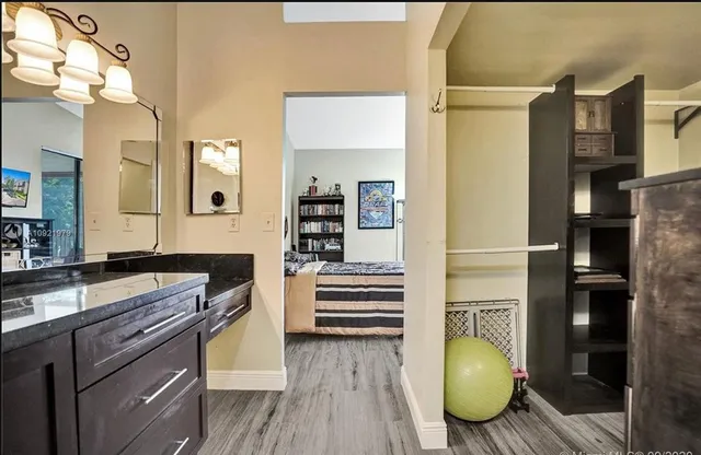 a kitchen with a sink and wooden floor