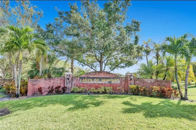 a view of a backyard with potted plants and large trees