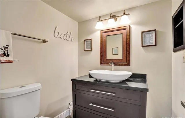 a bathroom with a sink a toilet and mirror