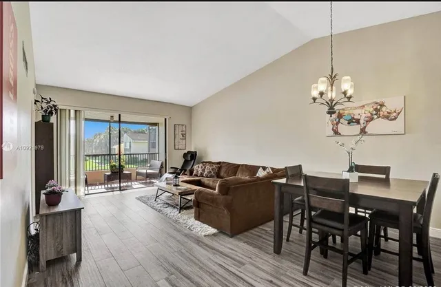 a living room with furniture a dining table and a chandelier
