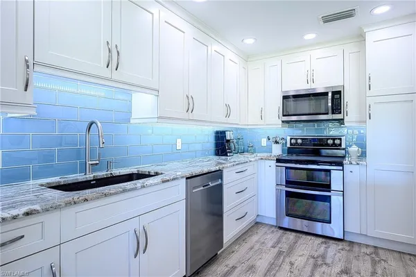 a kitchen with cabinets stainless steel appliances and a sink