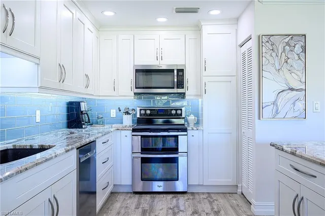 a kitchen with stainless steel appliances granite countertop a stove and a sink