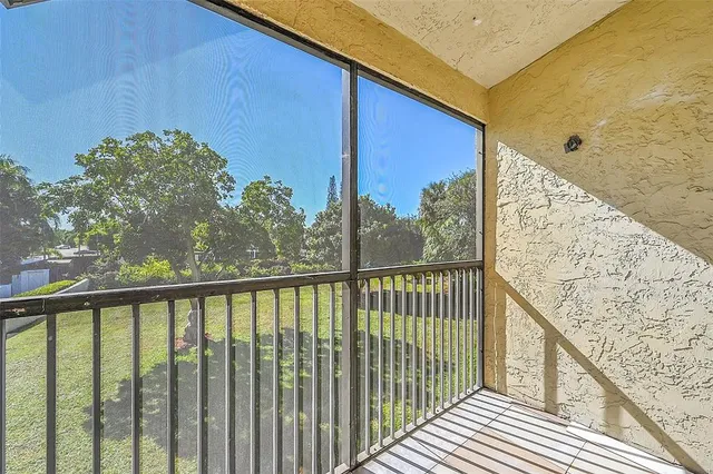 a view of a balcony with wooden floor & fence